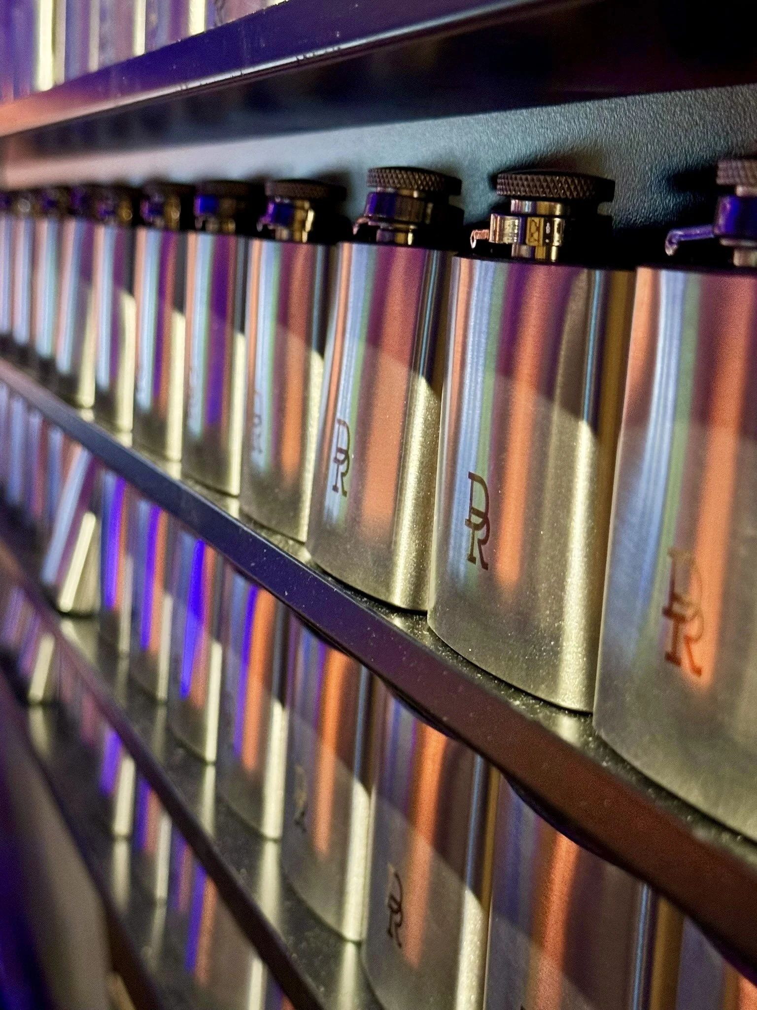 Row of hip flasks arranged for the live engraving experience