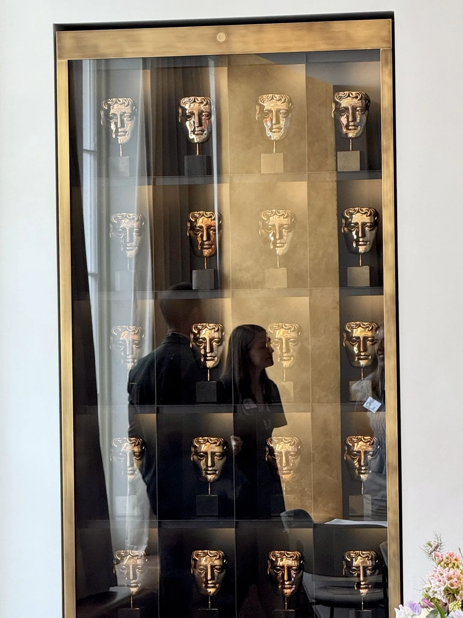 MakersCAFE display cabinet showcasing BAFTA award masks in a glass case.