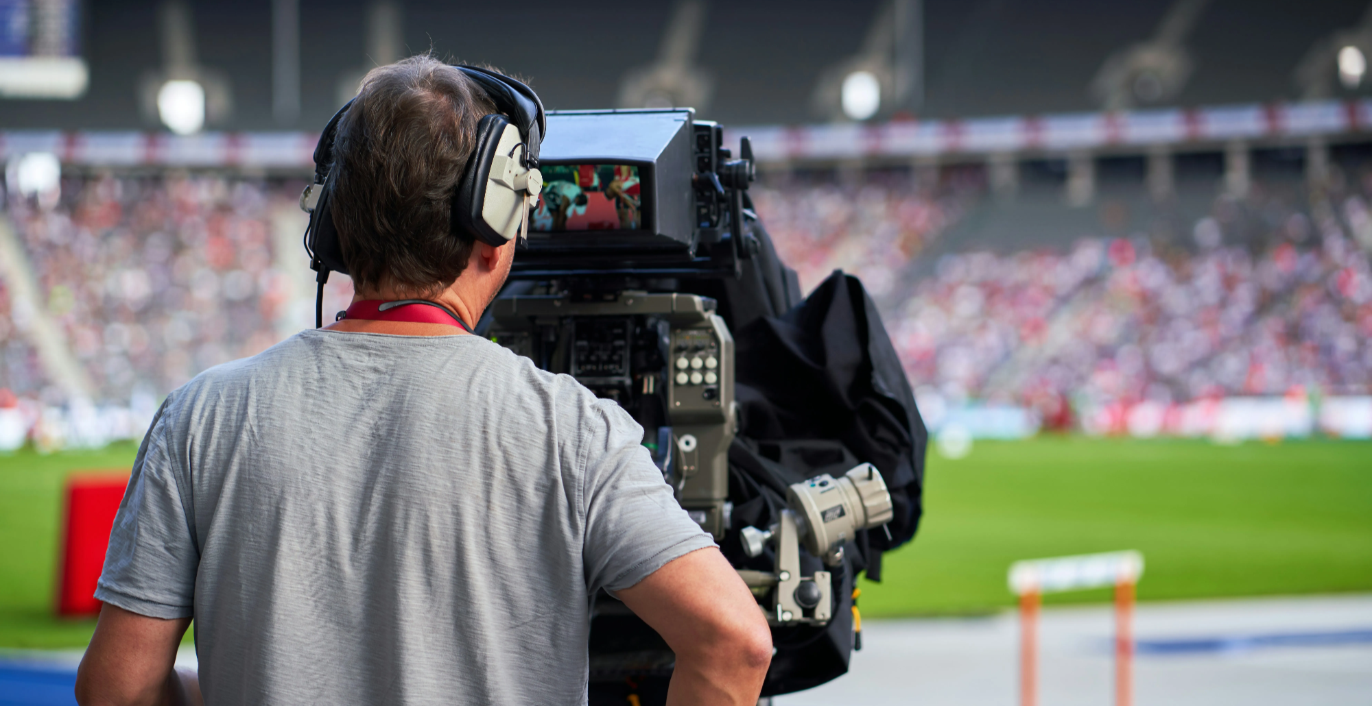 Camera operator filming a live sports event from the sidelines