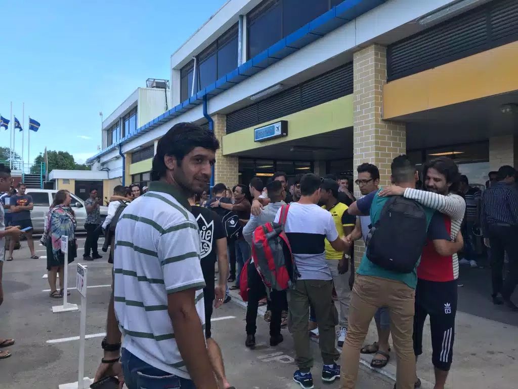 Refugees line up ahead of a transfer flight