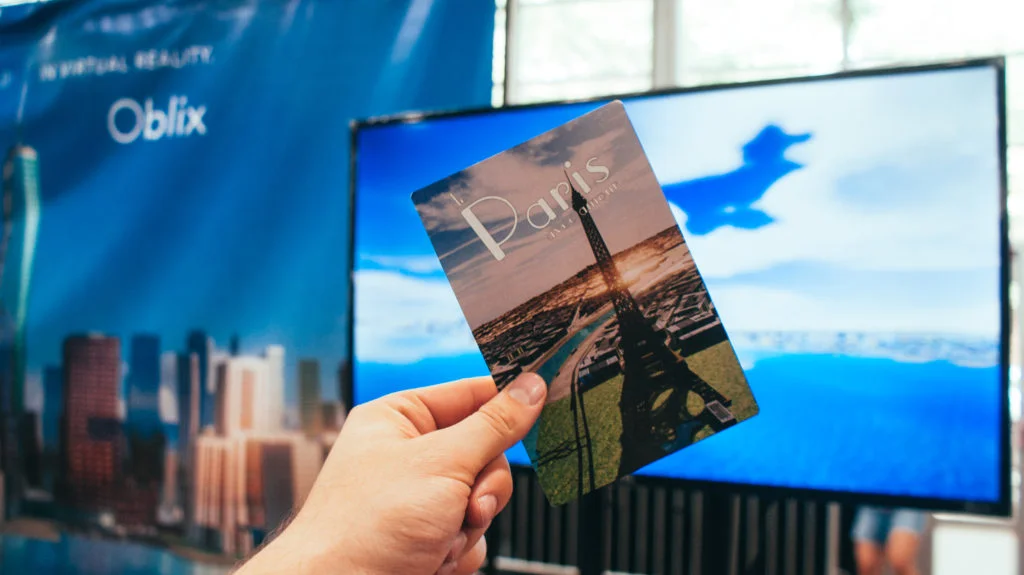 A postcard given away by Oblix with a screen capture from inside the experience.
