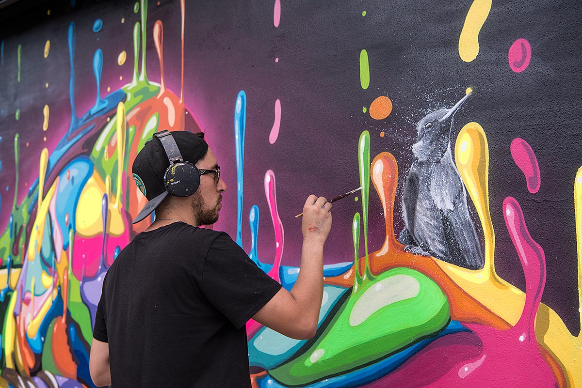 DASIC AT WORK ON HIS MURAL INSIDE THE WYNWOOD WALLS