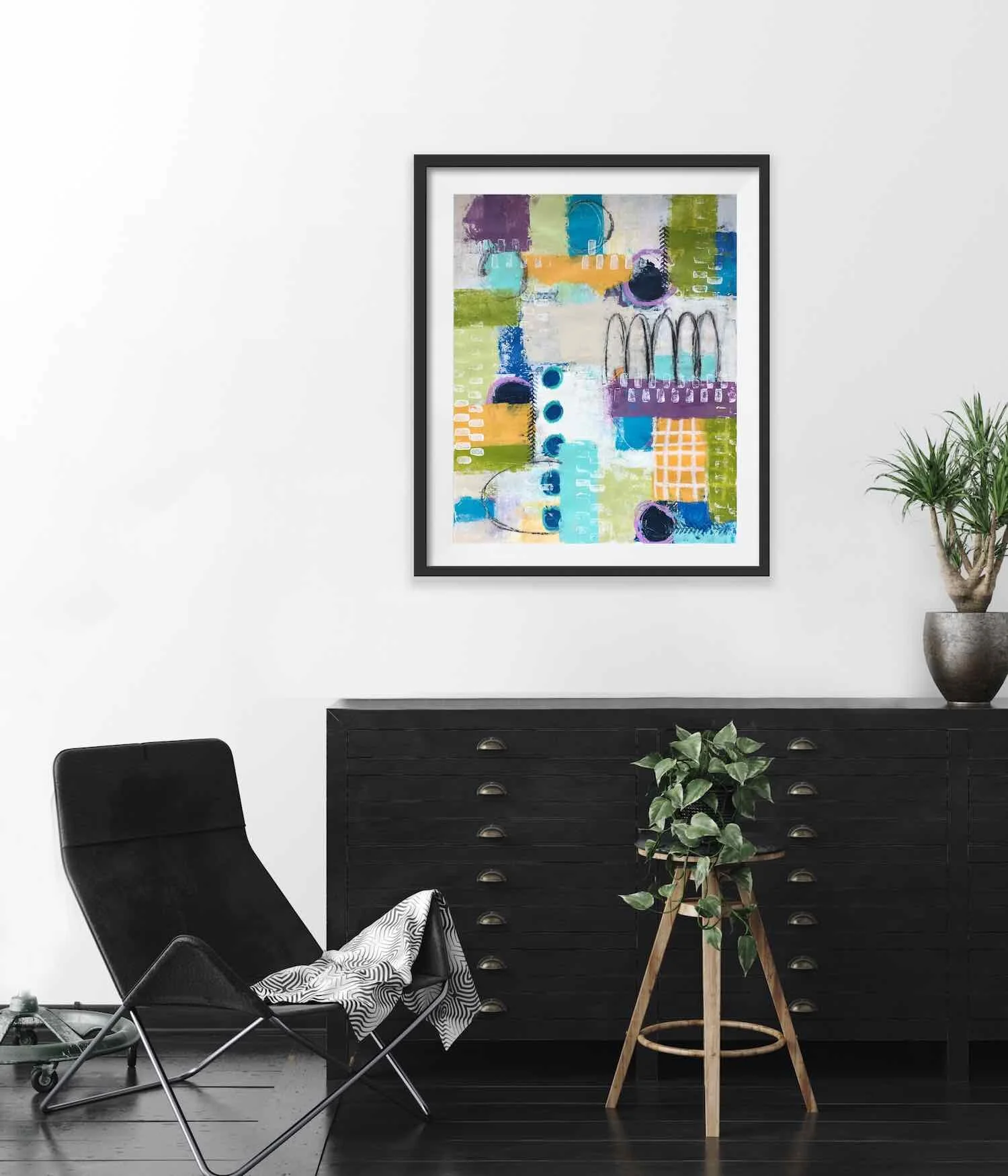 framed painting on wall above black dresser