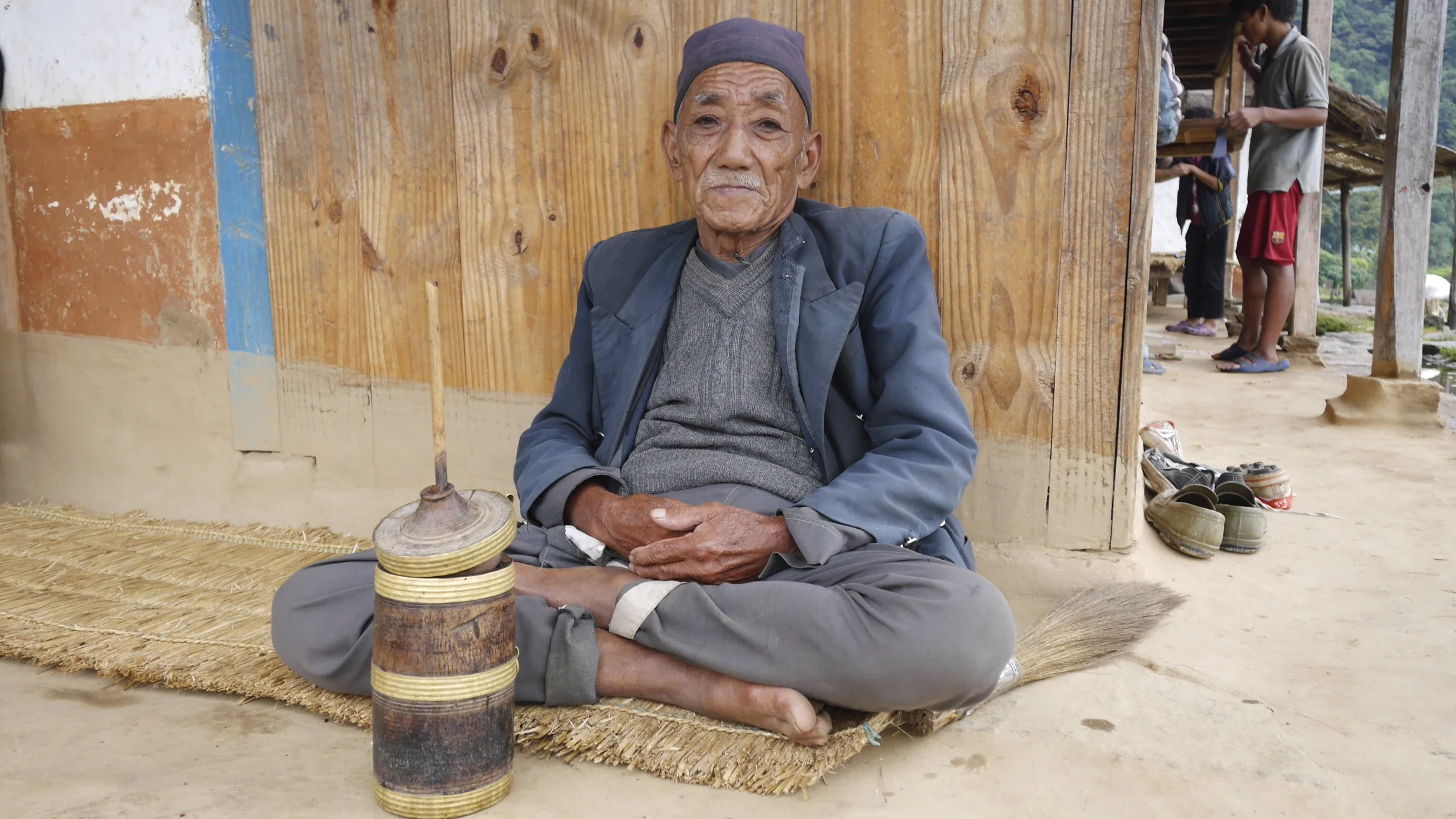 an old man enjoying his Tumba - a traditional beer-like drink served in the wooden tumblers.