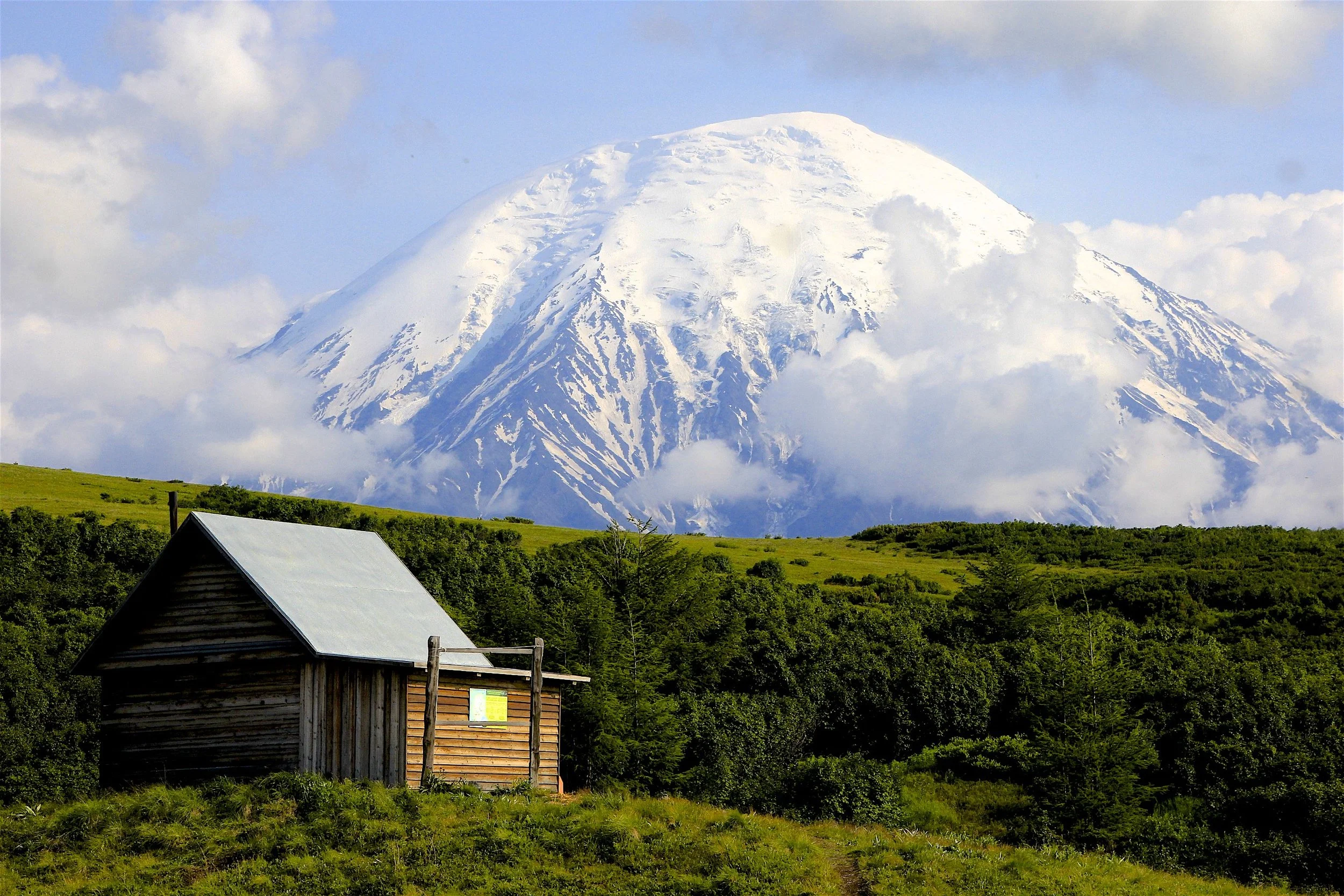 The simple shelters provide a welcome escape from the frequent and intense rain. The air temperature can vary by a lot in the matter of hours. The Ostry Tolbachik 3,672m dominates the view.