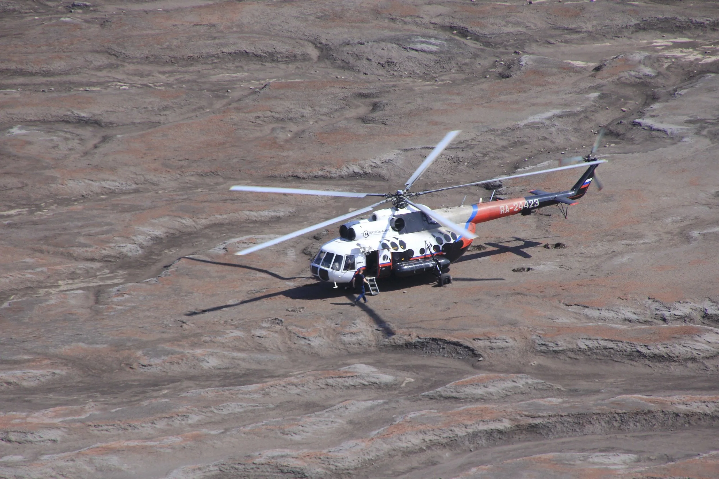 One can take a day trip to the Gorely crater from PK for around $700 US per person. The large Mi8 helicopter takes about 24 passengers. It has max cruising speed of 225km/h and a flight range of 900km. It is the most popular twin engine helicopter in the world. We observed their approach and landing. On the next photo, see the helicopter parked in front of the crater for scale!