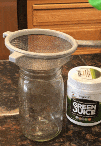 Pouring Green Juice Through a Strainer