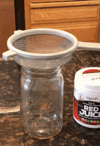 Pouring Red Juice Through a Strainer