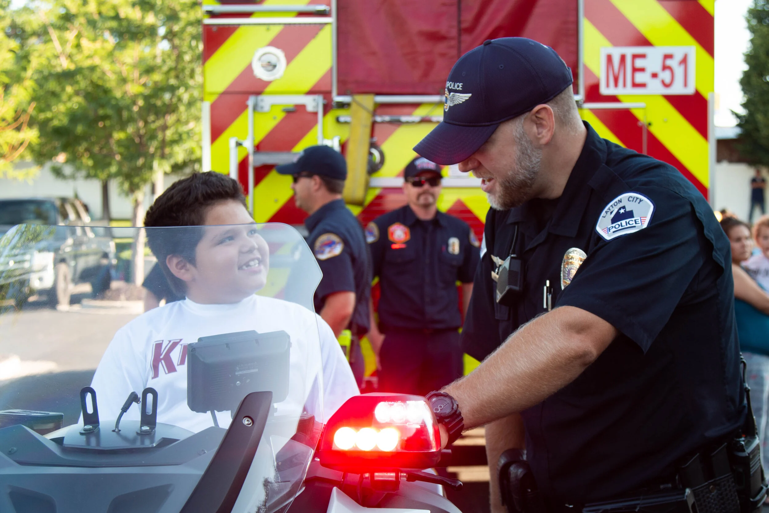 A Layton City officer lets a child try his patrol bike. 