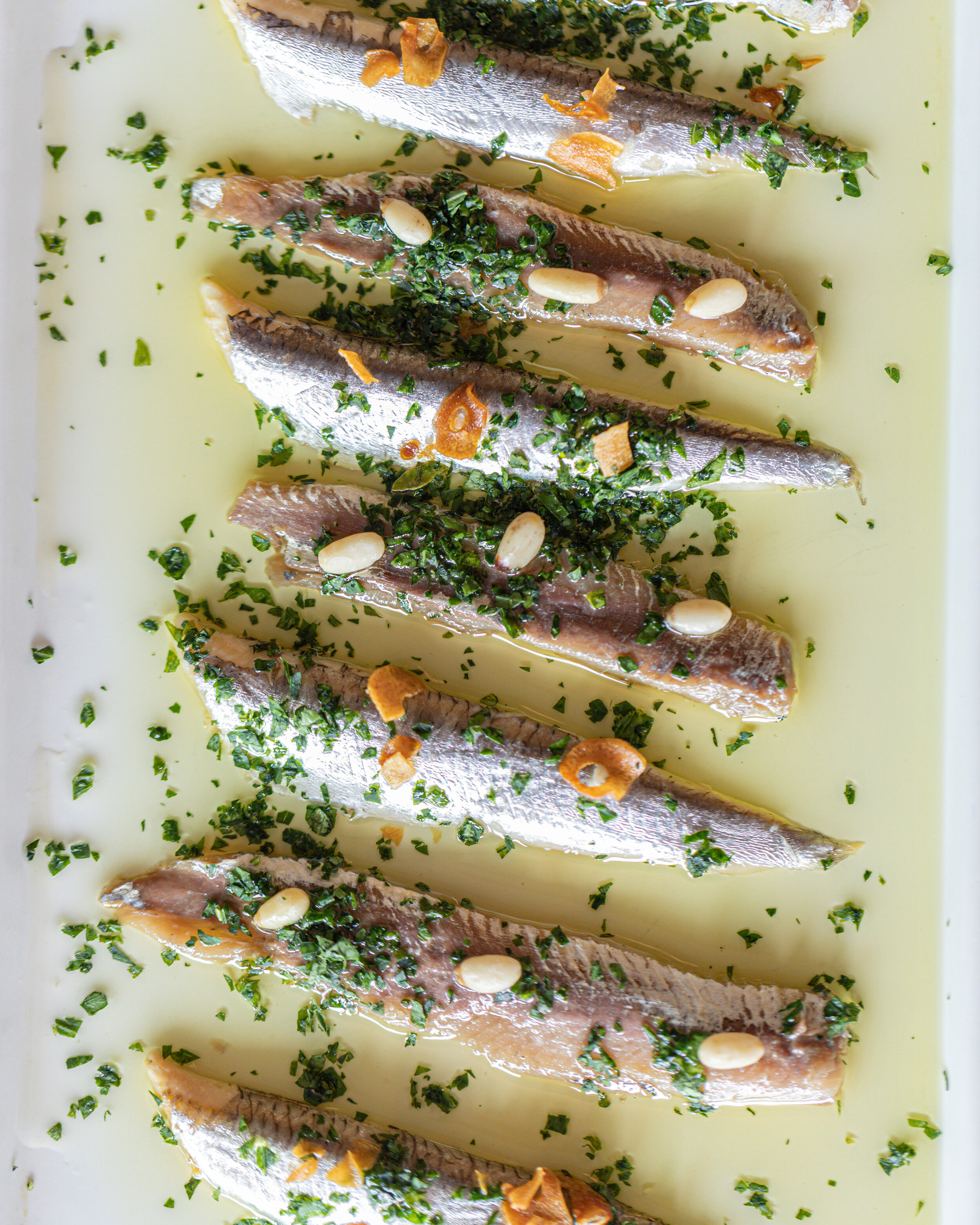 Dúo de anchoa y boquerón con aceite de olivo con piñón y hojuelas de ajo 2.jpg