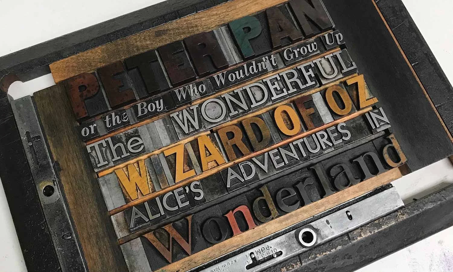 A lock-up of wood and metal letters, spelling out the full names of the three books.