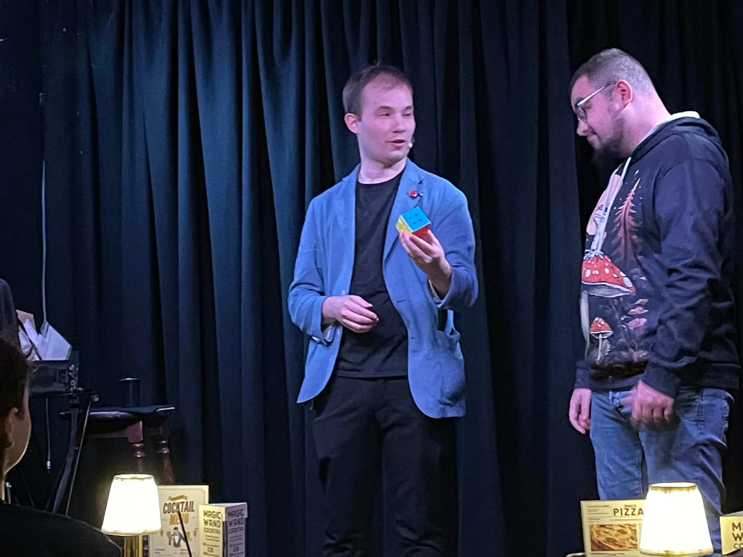 Jaie performing a comedy magic show on stage in weston-super-mare, performing magic with a rubiks cube
