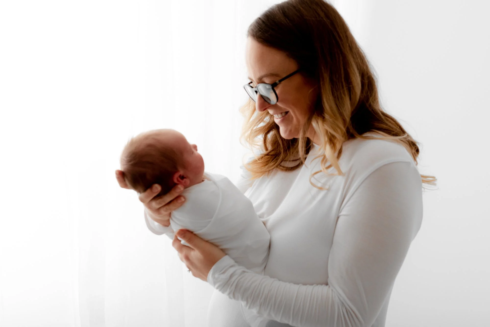Parents gently comforting their newborn during a baby-led photoshoot