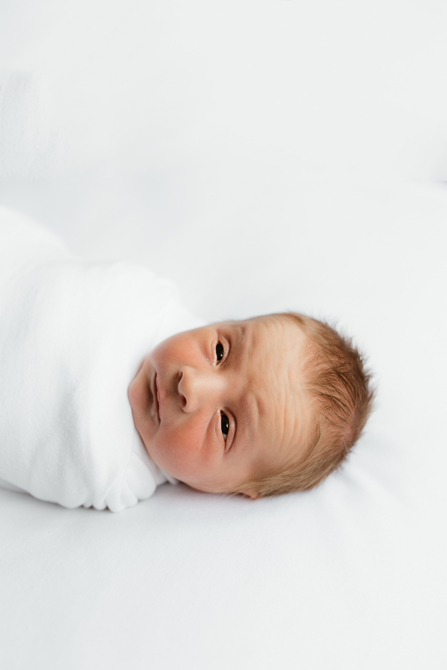 sleepy baby on white backdrop