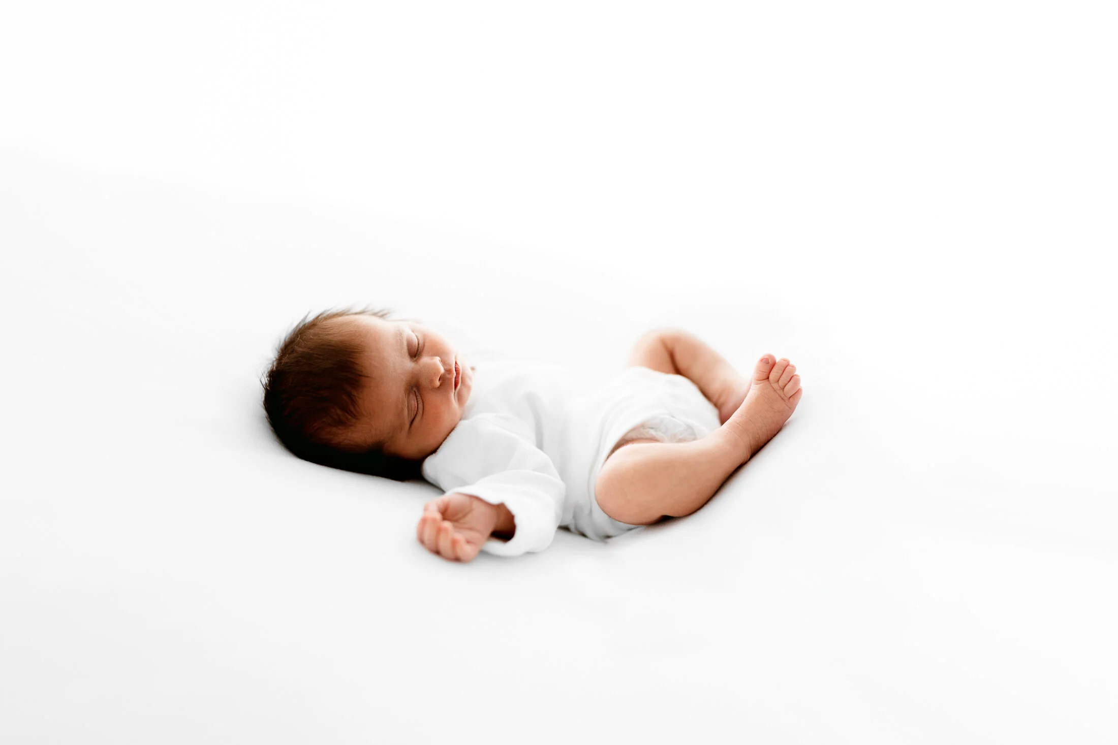natural newborn photography berkshire baby sleeping curled up studio
