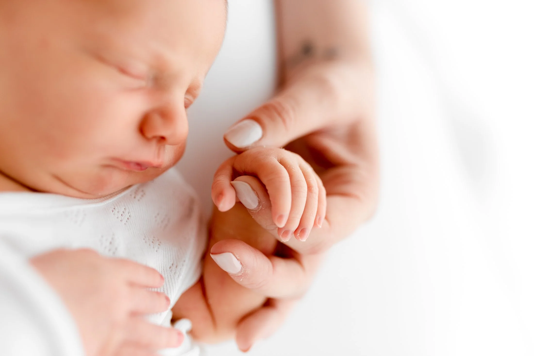 Newborn baby holding Mums hand