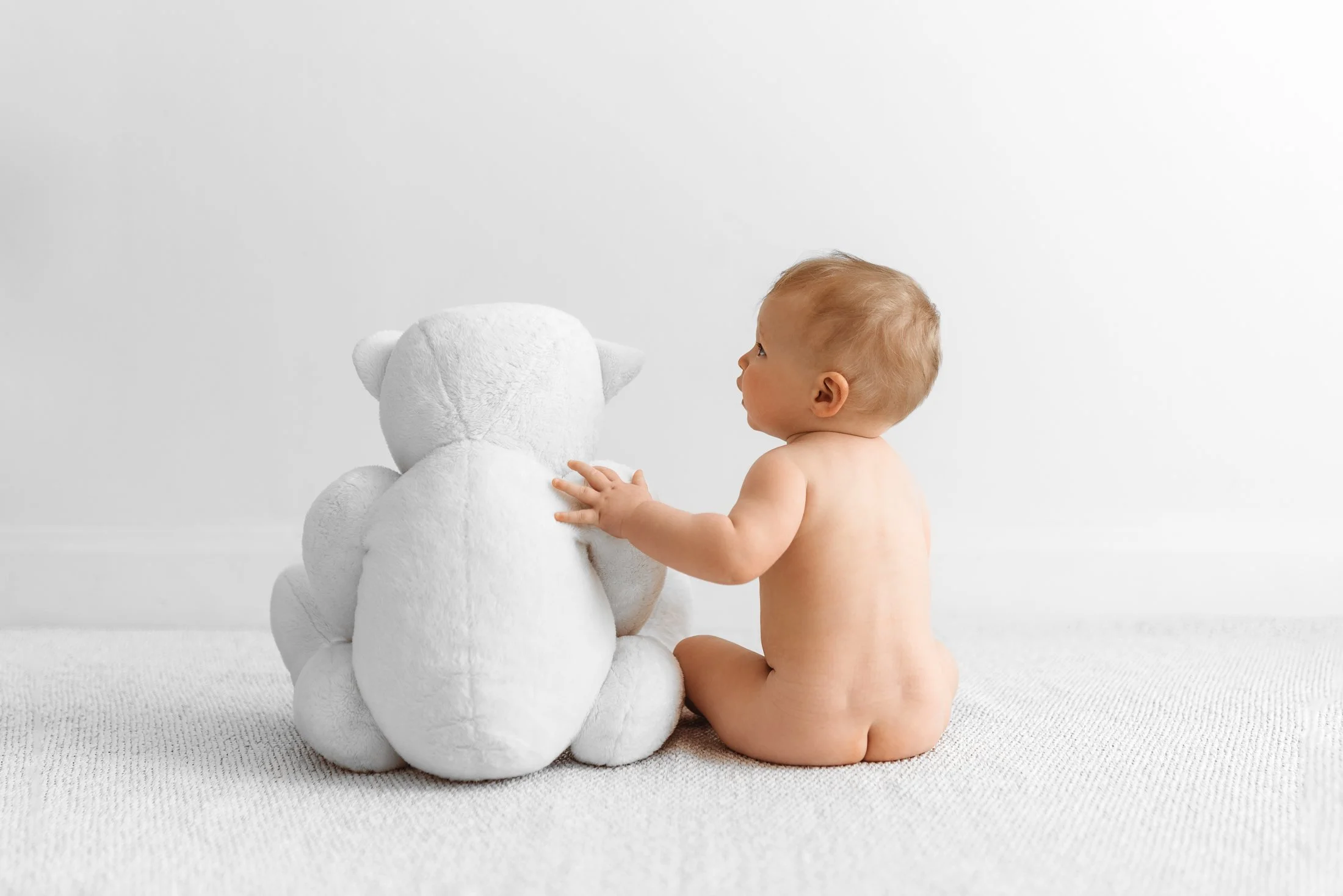 Baby sitting and playing during a natural milestone photoshoot