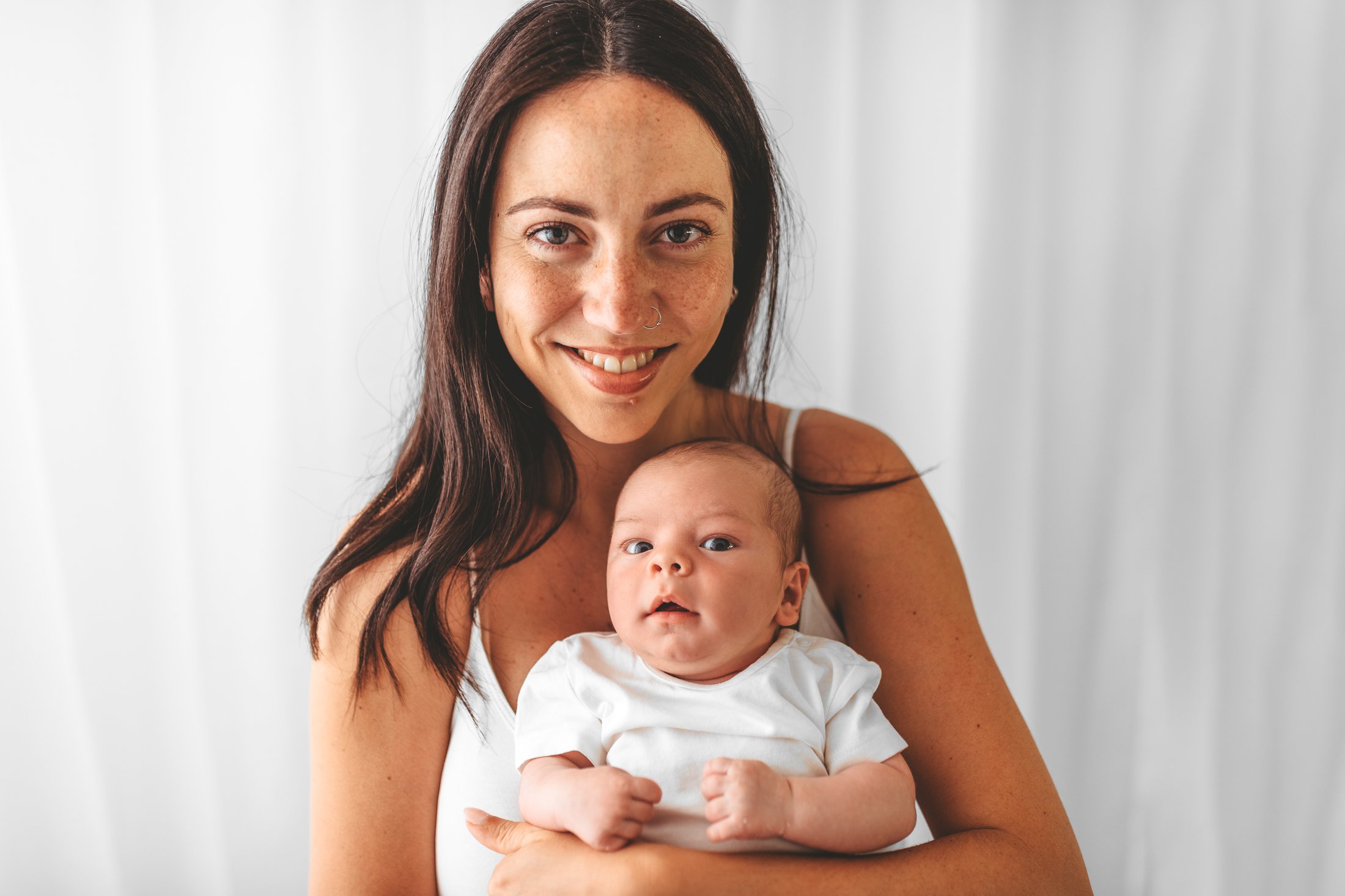 Parent gently comforting their newborn during a baby photoshoot