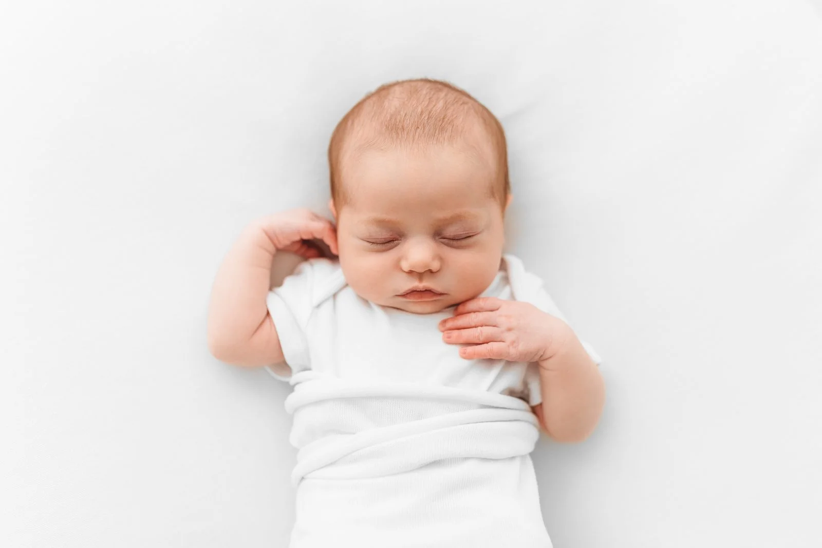 Newborn baby wrapped in neutral tones during a Wokingham studio photoshoot