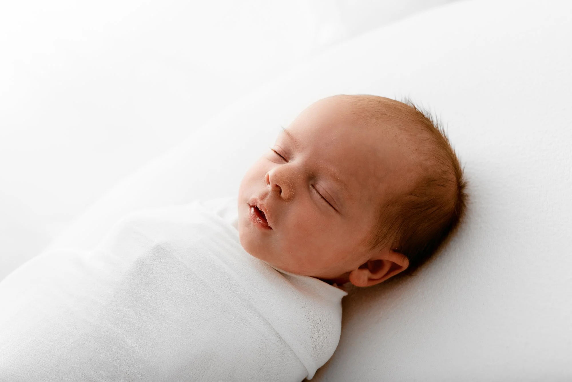 Newborn baby settled comfortably during a calm photography session