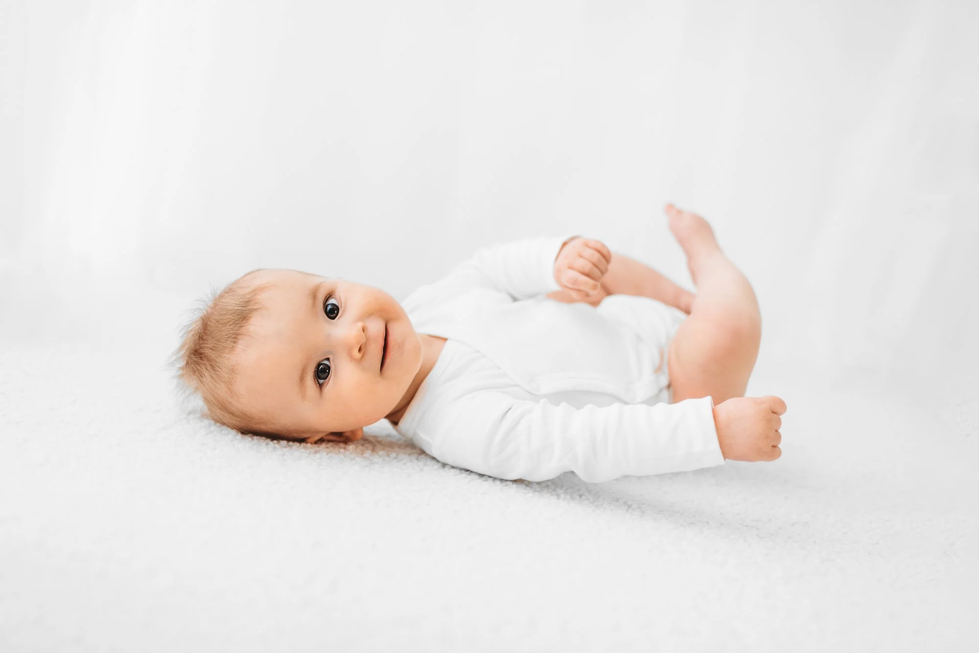 Baby smiling during a natural milestone photoshoot