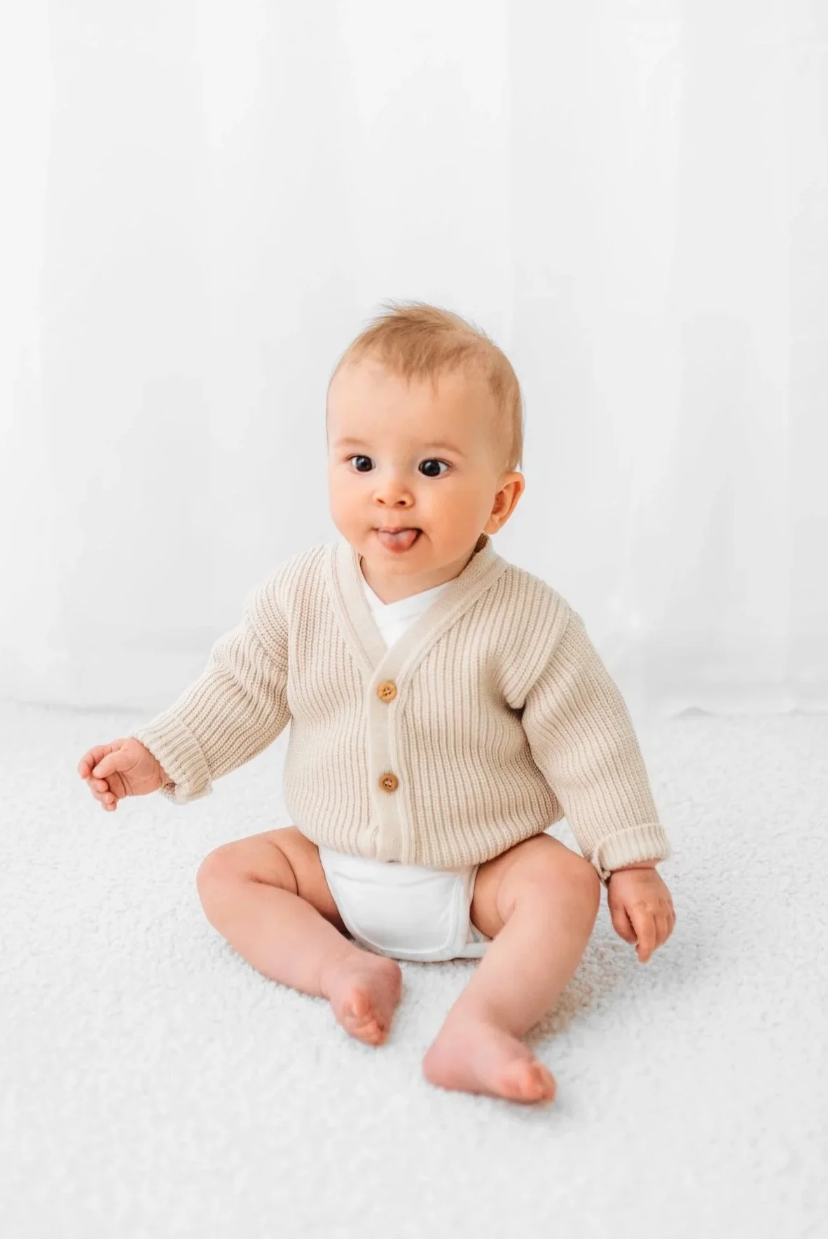 Six month old baby sitting independently during a milestone session