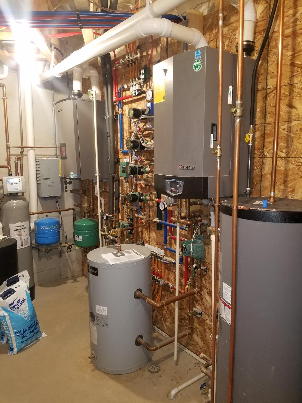  This residential heating system provides comfort while saving money. This high-efficiency modern boiler system not only provides in-floor heat to multiple independent zones in the house, but also has an air stage to make the system more responsive. 