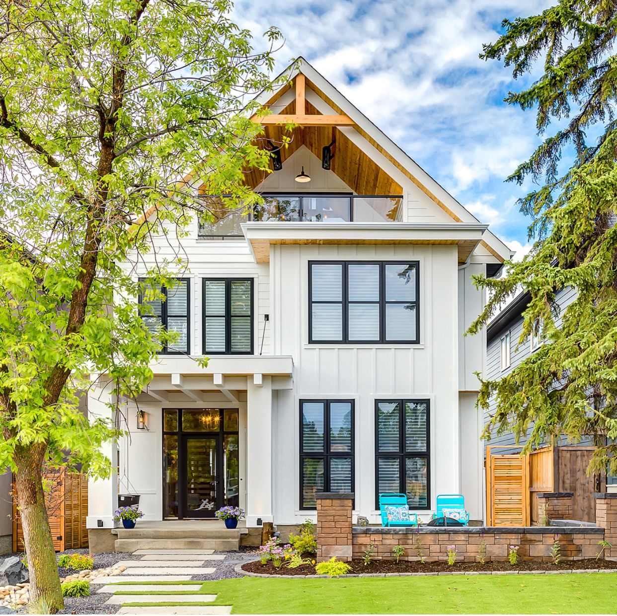 This white exterior paired with black framed windows is perfection. Love that upstairs balcony too! Lovely design from @tricklecreekyyc