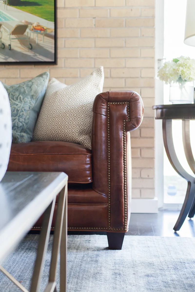 The Chester Sofa in Malawi Tonga features a sophisticated silhouette with tufted leather and classic nailhead detailing.