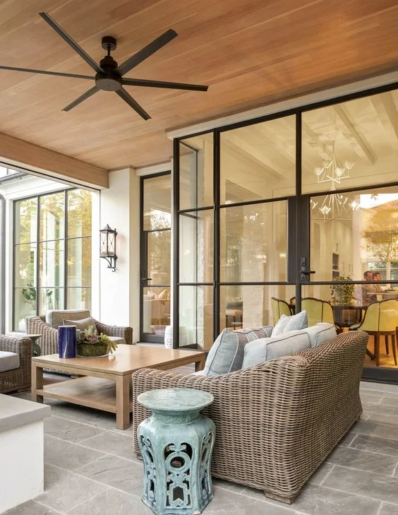 Space to entertain inside and out is a must in any home, and we could personally spend all day out here! Every detail from the ceiling fan to the colored accent table pull everything together beautifully.