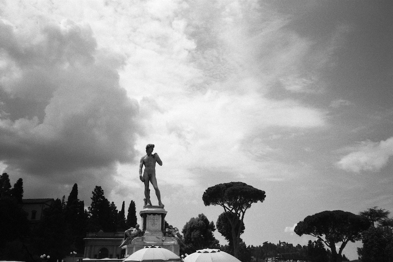 No. 107 ”Piazzale Michelangelo in Florence” Art starting at $73.40 | Shot on film at Piazzale Michelangelo, Florence, this black and white photograph features a recreation of Michelangelo’s David against a cloudy sky. Piazzale Michelangelo was built in 1869 and is dedicated to Renaissance sculptor Michelangelo, featuring bronze recreations of some of the sculptor’s most revered works.