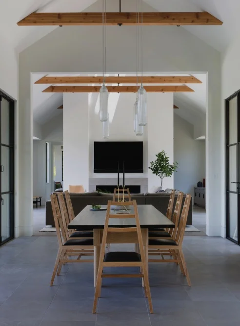 A-frames all the way | A second dining area in the home opens up to the living room, which also features a vaulted ceiling. These A-frame dining chairs seem to fit in perfectly!