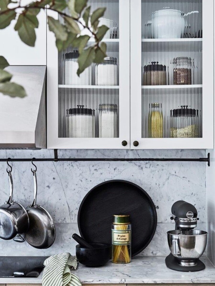 Fluting is also used in the these cabinet doors to partially expose the contents behind, while adding rich texture to the kitchen’s prep space.