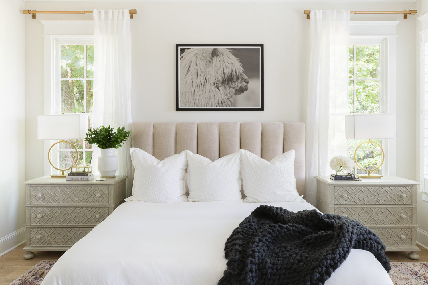upholstered bed with matching side tables and windows