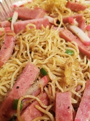 Fried noodles with spam, fish cake and green onion.