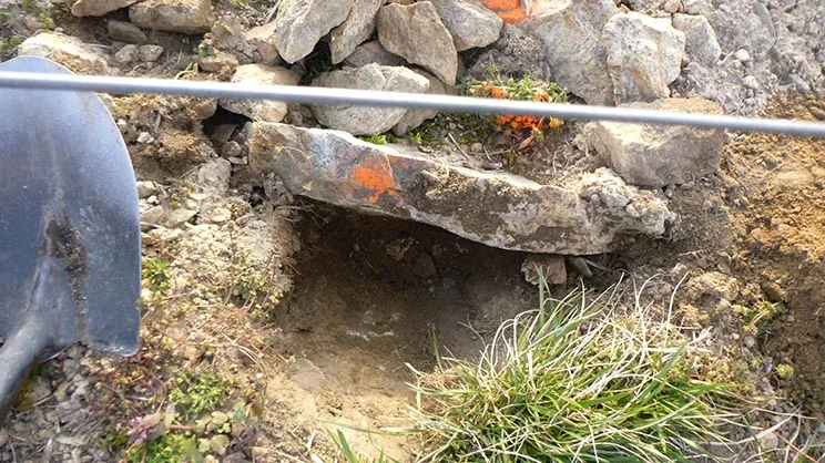 A hole is dug by hand.