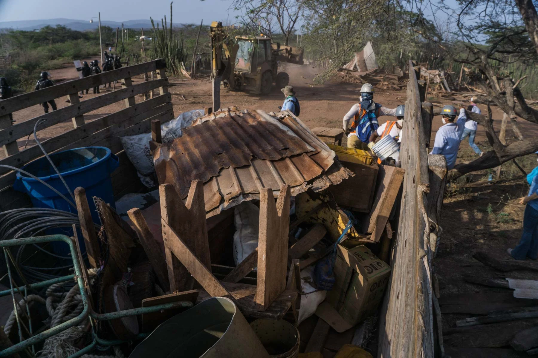 Employees from the mining company collect household belongings in trucks before proceeding with the demolition of the houses.