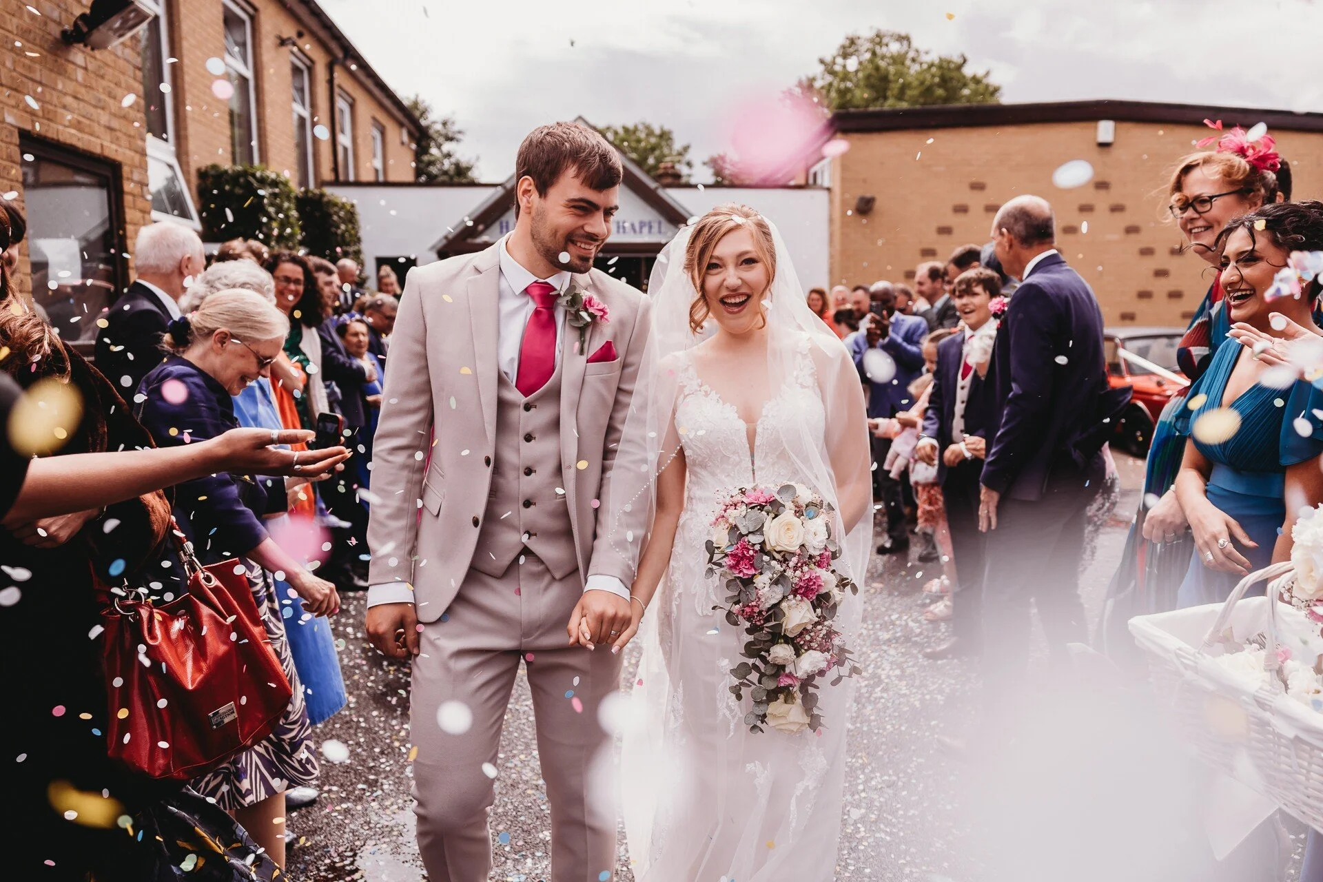 Bride and groom confetti walk at a church