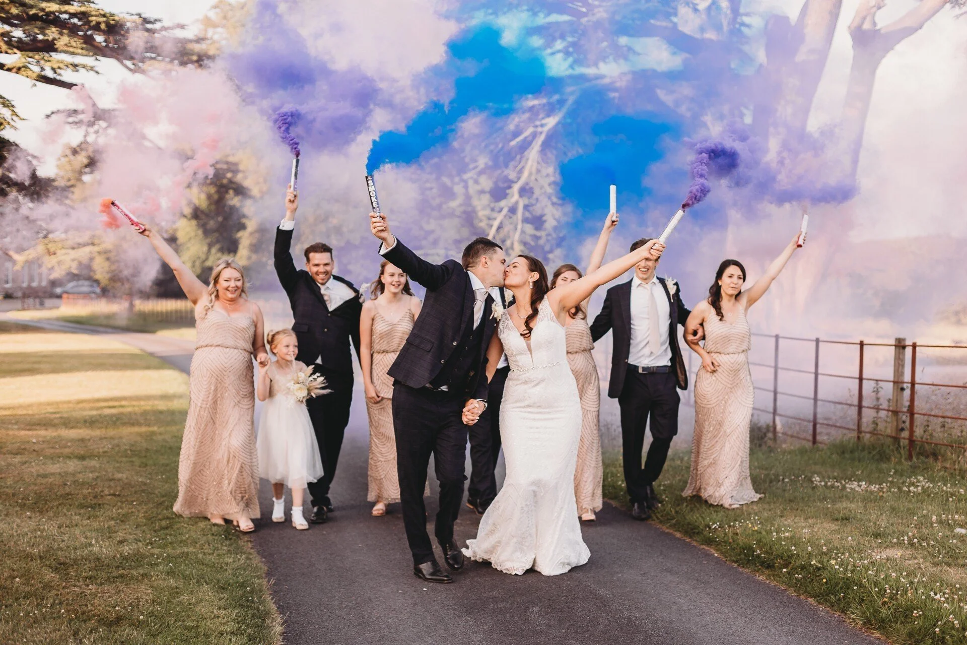 Bride and groom with bridal party celebrating with smoke bombs
