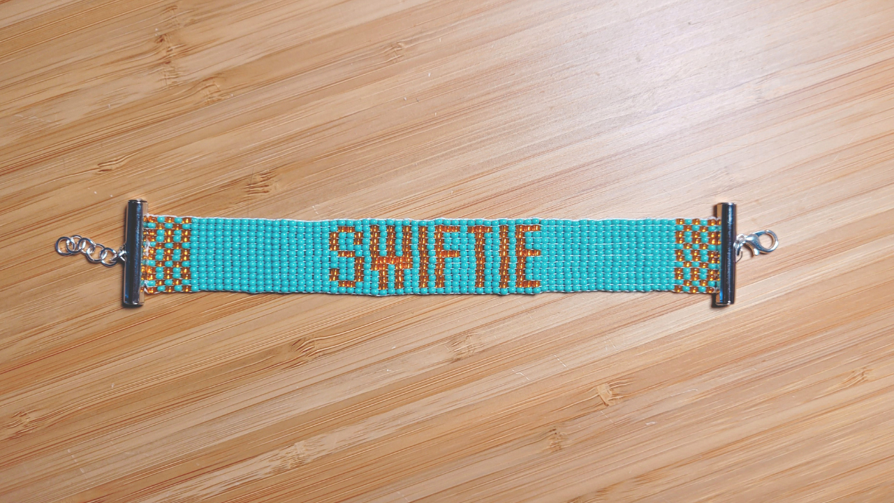 A beaded bracelet that says 'Swiftie'