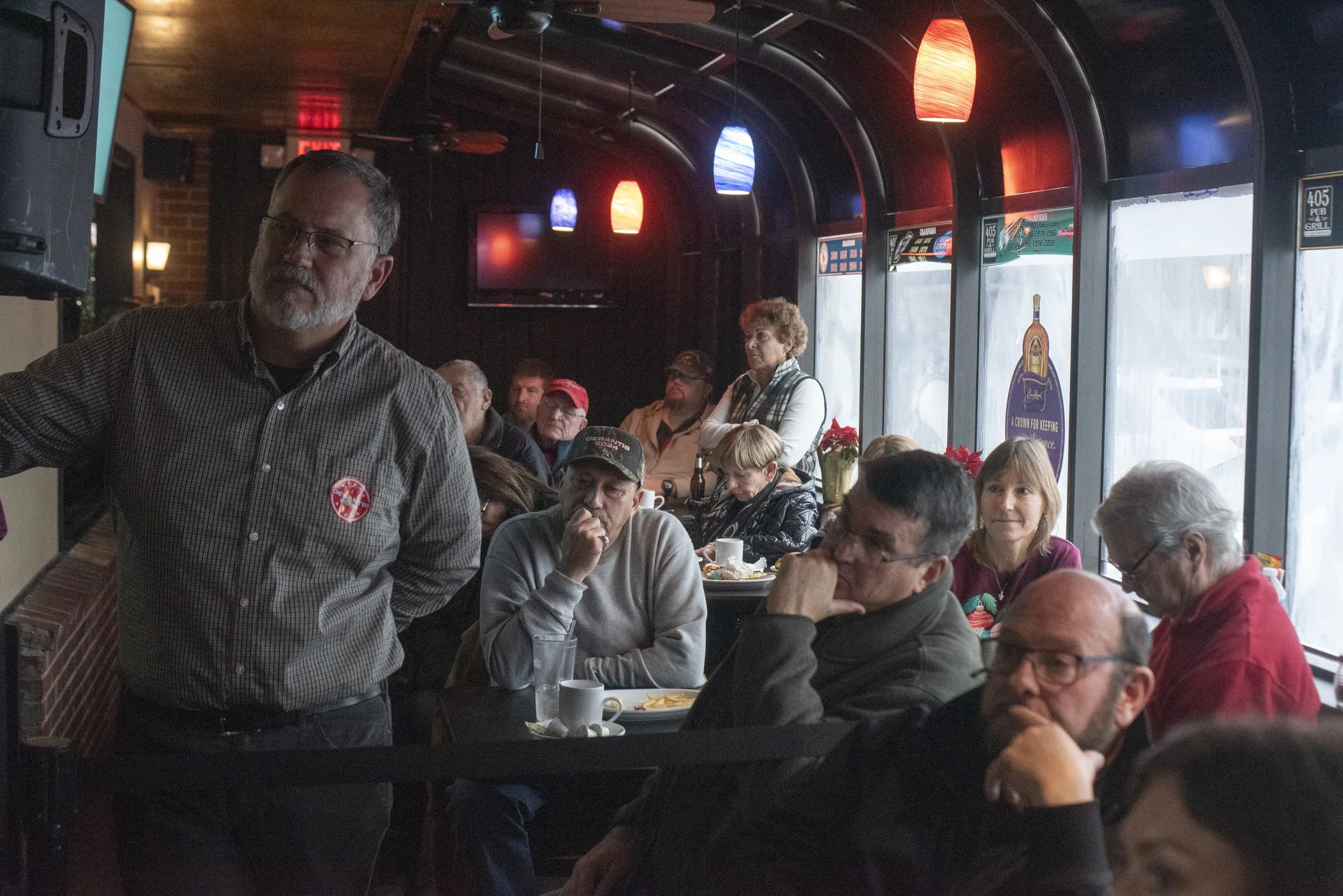  People listen to Florida Gov. Ron DeSantis as he speaks and answers questions at 405 Pub &amp; Grill in Laconia, N.H., on Dec. 4, 2023. 