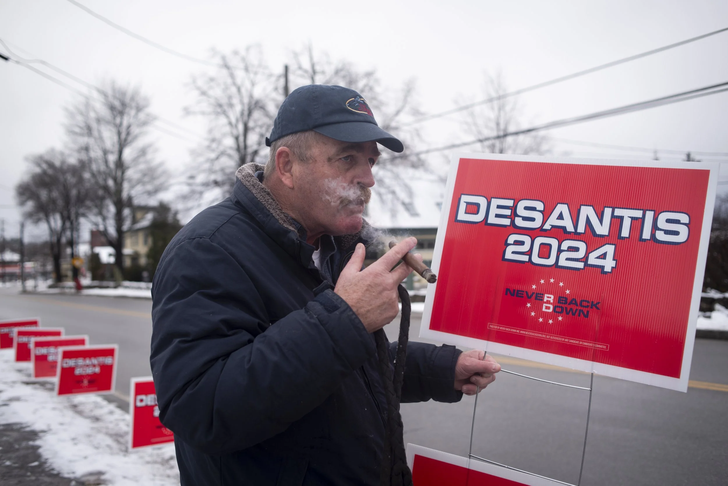  Mark Bates smokes a cigar while supporting Florida Gov. Ron DeSantis before he speaks at 405 Pub & Grill in Laconia, N.H., Dec. 4, 2023. Former President Donald Trump is Bates’ first pick for the 2024 candidacy, but came to support DeSantis as a bac