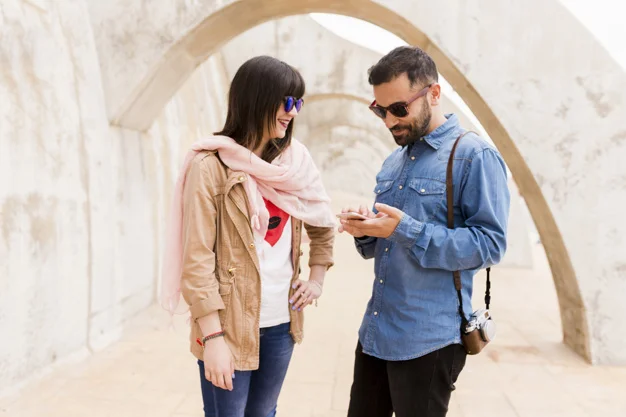 smiling-young-woman-looking-at-man-using-cell-phone_23-2147863507.jpg