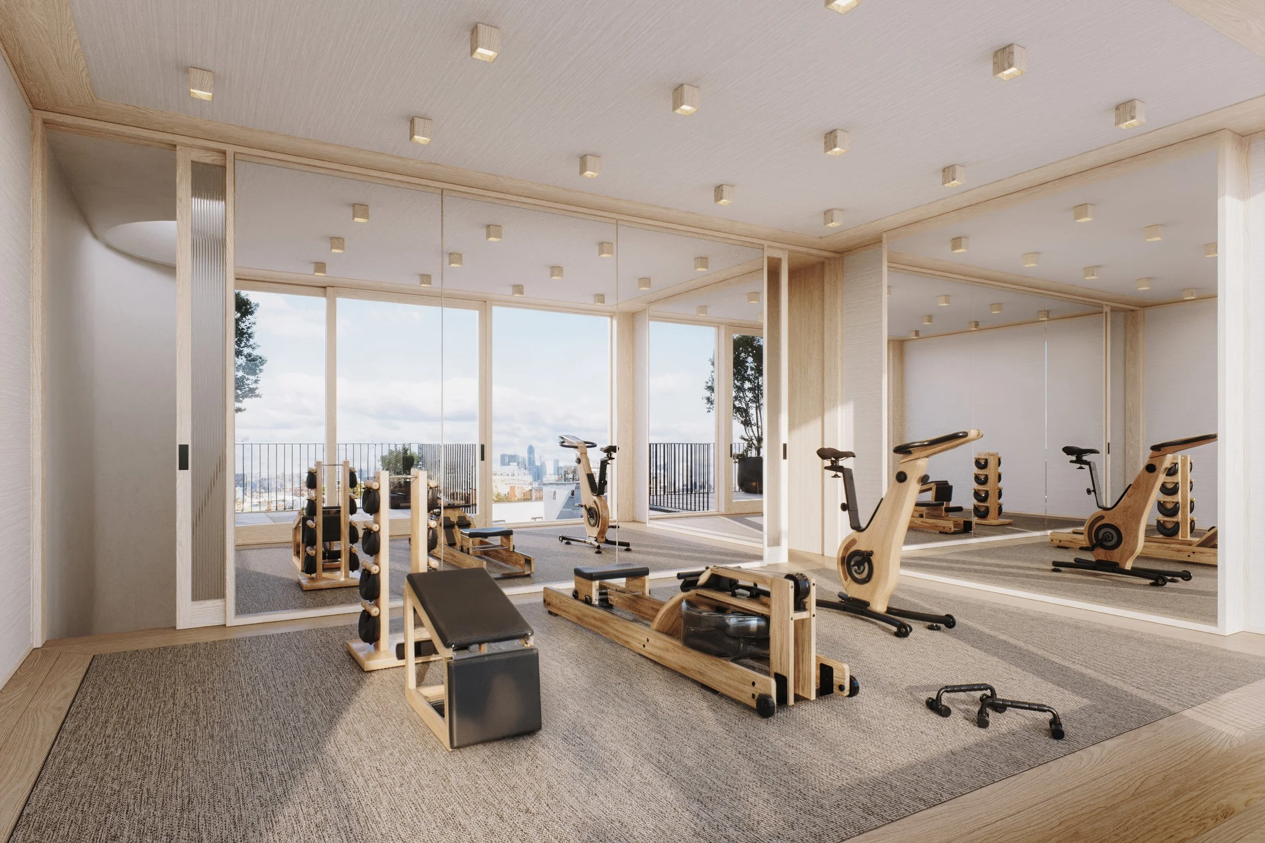 A modern fitness room with wooden exercise equipment including stationary bikes, dumbbell racks, and a Pilates reformer, with large windows overlooking a city skyline.
