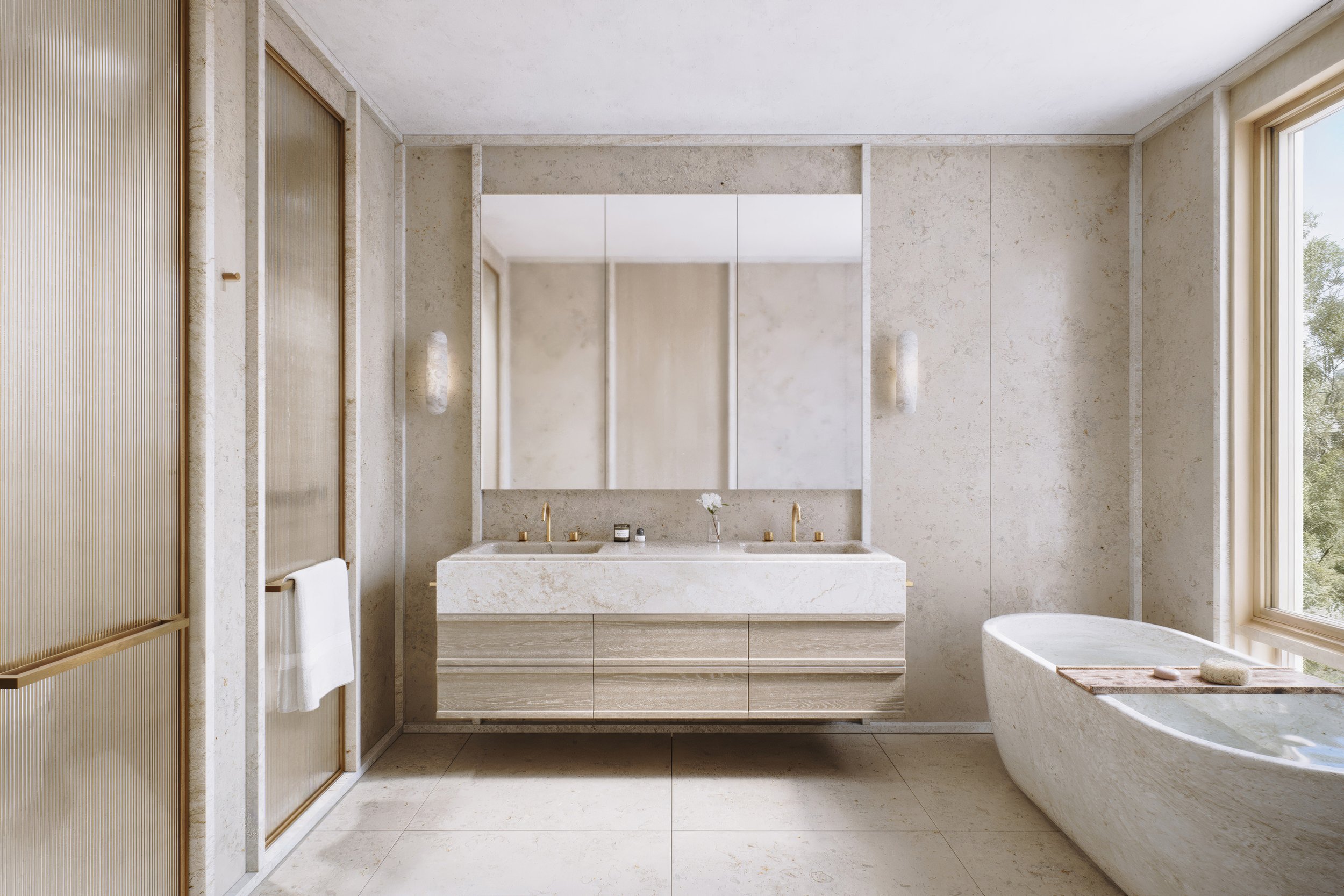 Modern bathroom with large mirror, dual sinks with gold fixtures, beige stone walls, bathtub by window, and minimalist decor.