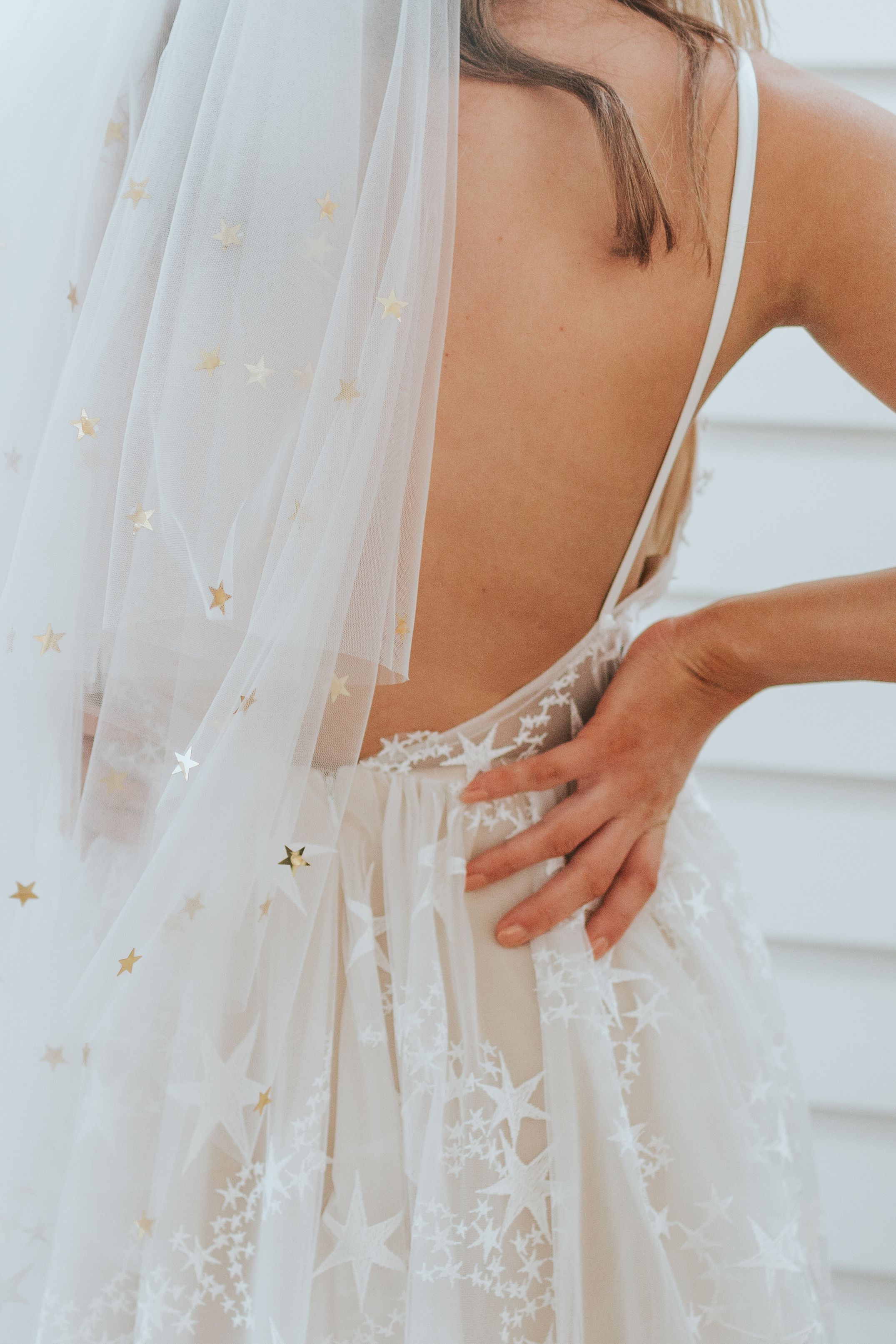 Our celestial AMALFI gown will have you seeing stars, quite literally, with its star-patterned dreamy tulle. A v-neckline bodice and fully pleated skirt complete this one-of-a-kind star bride look. Made for the romantic, free-spirited woman who keeps you on your toes. Pair this gown with this gold starry veil for the perfect combo.