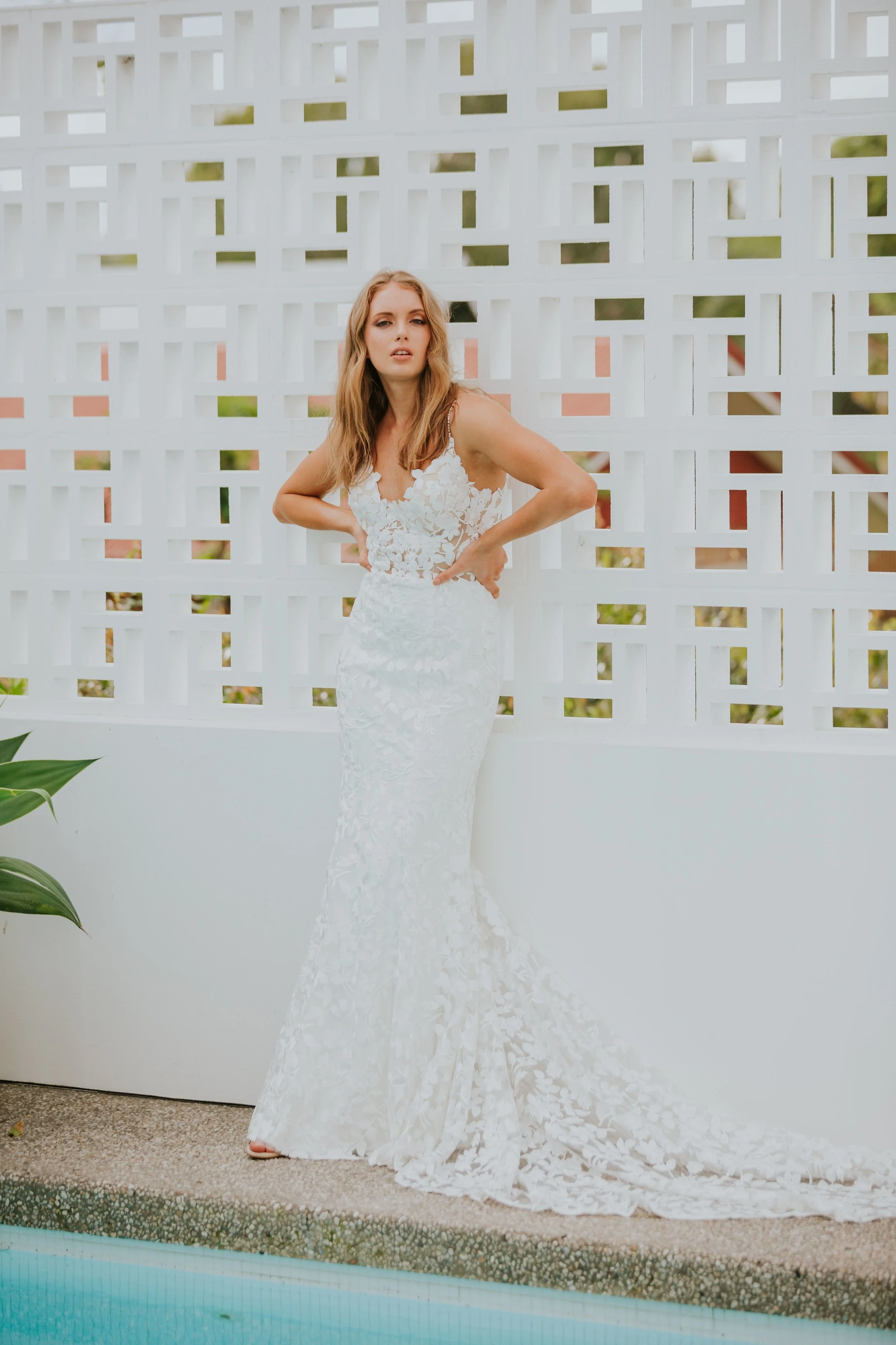 Our BALI gown is the dress you put on and never want to take off again. Made cool, luxe bride using our exclusive ivory floral textured lace. Her heart-stopping detail is in the crystal embellished spaghetti straps that span over the shoulders and down a revealing open back.