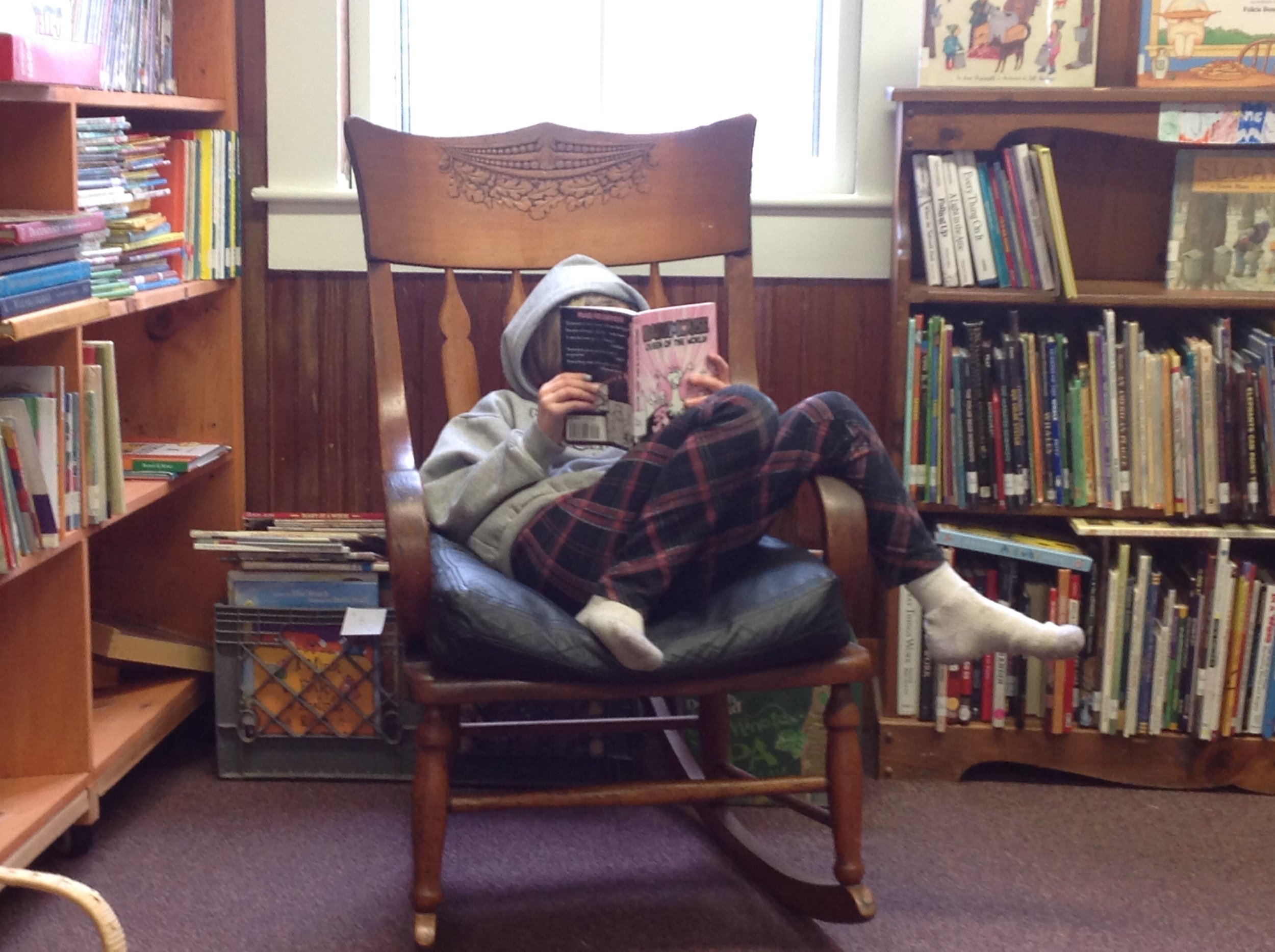 A patron, reading her book in our cozy library seting.