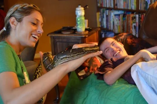 Meredith Hughes, manager of Cincinnati Zoo & Botanical Garden's Creature Connections, shows Dylan Malling, of Anderson Township, a snake during a visit in 2019.