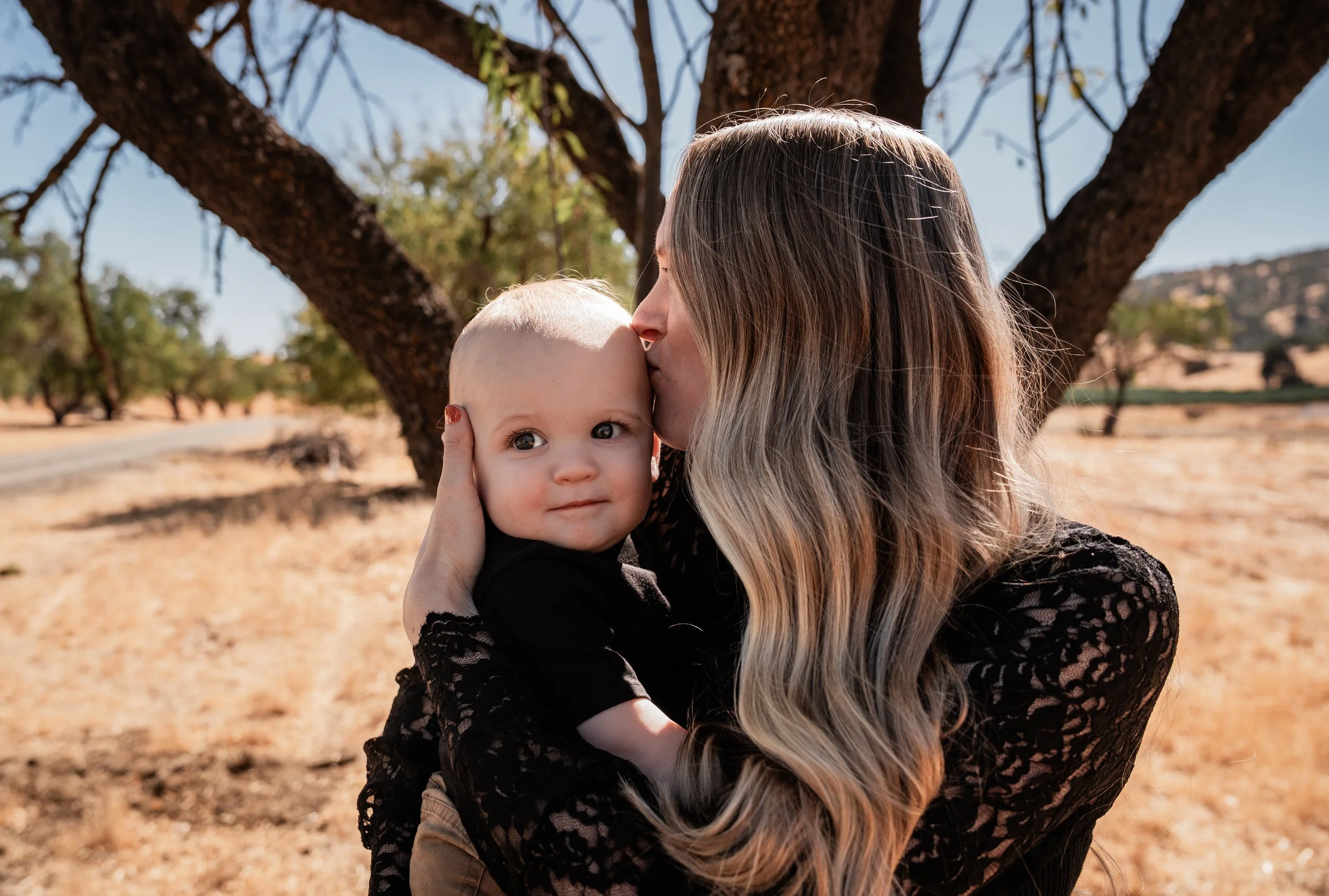 Mom giving her son a kiss in Capay, CA. Photo taken by maternity photographer, Mikaela Tosta Photography.